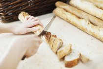 Chef cutting breadstick — Stock Photo