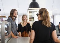 Friends talking with waitress — Stock Photo