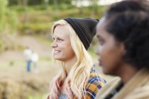 Smiling woman standing with friend outdoors — Stock Photo