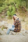 Жінка сидить на скелі в лісі — стокове фото
