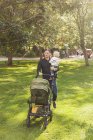 Father pushing baby carriage — Stock Photo
