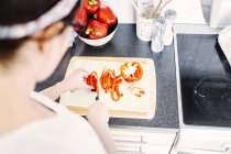 Woman cutting red bell pepper — Stock Photo