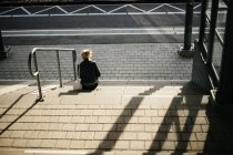 Женщина сидит на ступеньках — стоковое фото