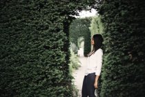 Woman leaning on bushes — Stock Photo