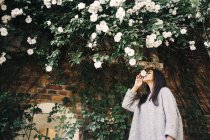 Женщина, нюхающая белый цветок — стоковое фото