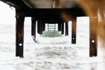 Underneath view of pier over sea — Stock Photo