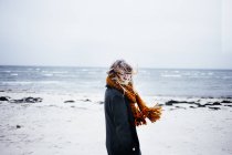 Молода жінка в шарфі на пляжі — стокове фото