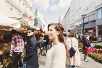 Smiling woman looking at market stal — Stock Photo