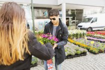 Jeune homme achetant pots de fleurs — Photo de stock