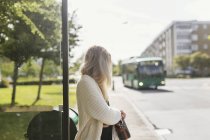 Молодая женщина на автобусной остановке — стоковое фото