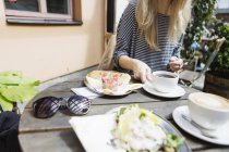 Woman having food at sidewalk cafe — Stock Photo