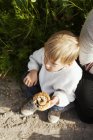 Мальчик держит булочку с корицей — стоковое фото