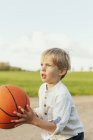 Хлопчик кидає баскетбол — стокове фото