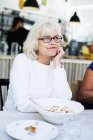 Старша жінка сидить у ресторані — стокове фото
