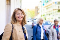 Senior woman standing with friends — Stock Photo