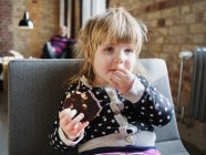 Little girl eating brownie — Stock Photo