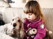 Chica con perro y juguete suave - foto de stock