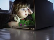 Mädchen schaut auf Laptop — Stockfoto