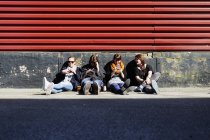 Amici che utilizzano smartphone per strada — Foto stock