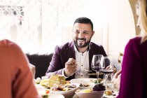 Mann isst mit Freunden zu Abend — Stockfoto