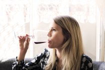 Жінка п'є червоне вино — стокове фото