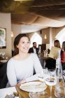Happy woman sitting at table — Stock Photo