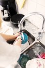Женщина стирает посуду в раковине — стоковое фото
