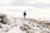 Mujer joven caminando en la playa - foto de stock