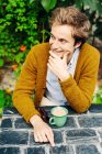 Усміхнений молодий чоловік має каву — стокове фото