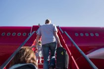 People walking on staircase towards airplane — Stock Photo