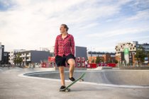 Женщина балансирует на скейтборде — стоковое фото
