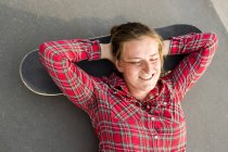 Donna sdraiata testa sullo skateboard — Foto stock
