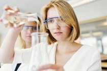 Female students performing science experiment — Stock Photo