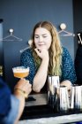 Бармен, служачи склянку коктейль для жінки — стокове фото