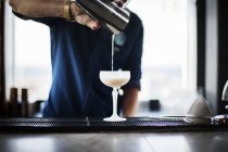 Бармен наливает коктейль в стакан — стоковое фото