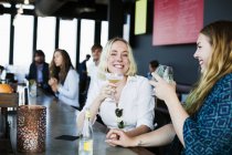 Lesbian couple holding hands at bar — Stock Photo