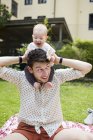 Father carrying baby girl on shoulders — Stock Photo