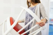Woman carrying chair — Stock Photo