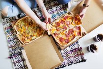 Friends eating pizza in new home — Stock Photo