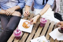 Couple having cupcake and smoothies — Stock Photo