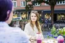 Жінки сидять у тротуарному кафе — стокове фото