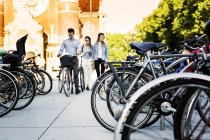 Друзья с велосипедами ходят по улице — стоковое фото