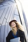 Glückliche Frau mit Hut gegen Bau — Stockfoto