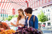 Amici che acquistano frutta al mercato — Foto stock
