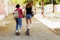 Teenage girls skateboarding by wall — Stock Photo