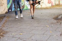 Девушки держат скейтборды и ходьба — стоковое фото