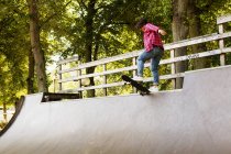 Девушка, стоящая на скейтборде на рампе — стоковое фото