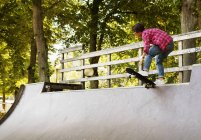 Fille debout sur le skateboard sur la rampe — Photo de stock