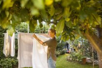 Woman hanging laundry on clothesline — Stock Photo