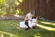 Chica jugando con gato en el patio trasero - foto de stock